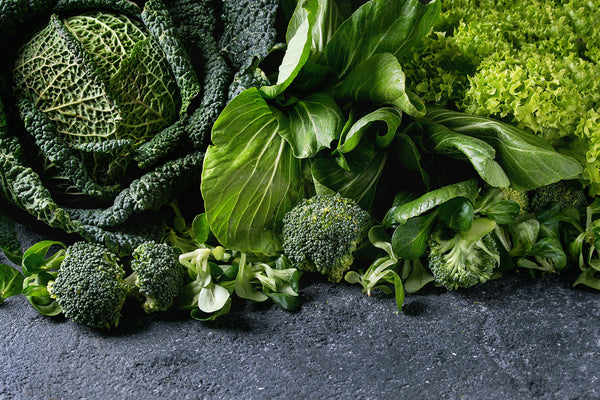 A variety of green vegetables, including broccoli, cabbage, and lettuce