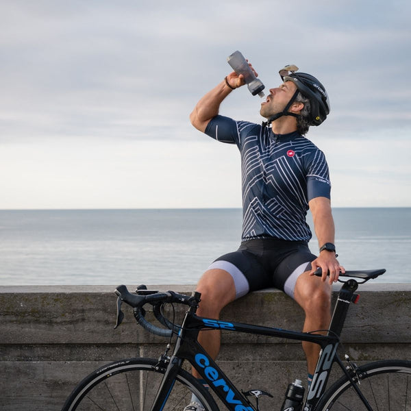 guy drinking water on bike exercise